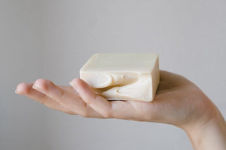 a lady's hand with a bar of triple milled soap resting in her palm